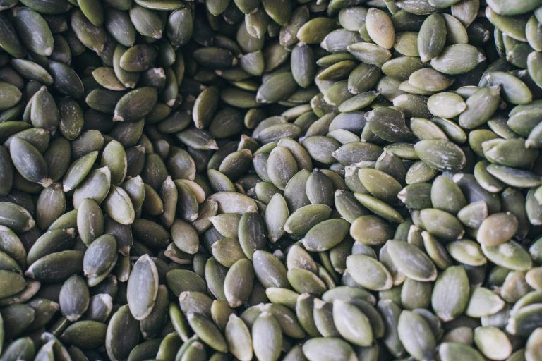 A close-up shot of organic pumpkin seeds showcasing their natural texture and green hue.